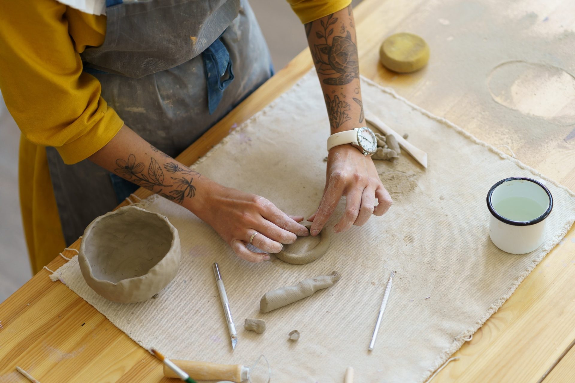 cropped-image-of-woman-learning-how-to-make-hand-formed-tableware-during-pottery-masterclass-e1656927034232.jpg